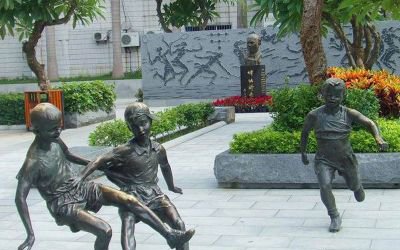公園景觀玻璃鋼仿銅小孩踢足球雕塑