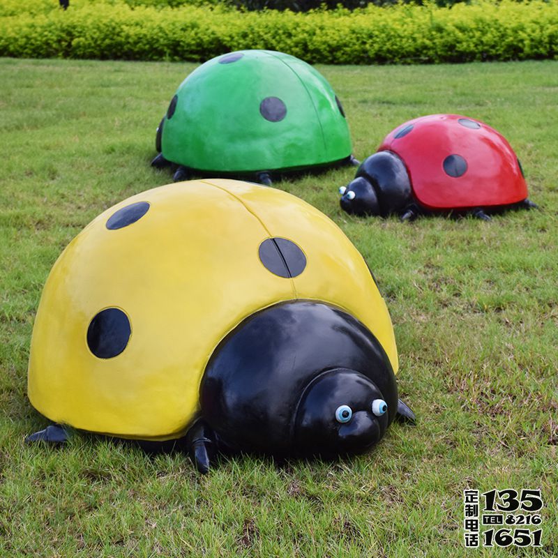 草地上擺放的三只不同顏色的玻璃鋼彩繪七星瓢蟲(chóng)雕塑